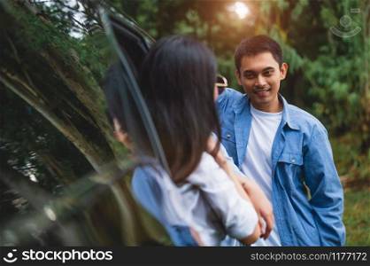 Asian man talking to women in car during travel in forest. Boy flirting girls for meeting. People lifestyles and weekend tour concept. Summer and nature theme. Mountain camping people group in holiday