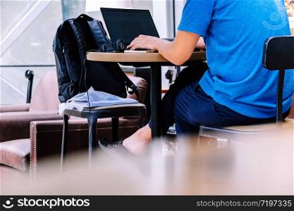 Asian man using laptop in cafe