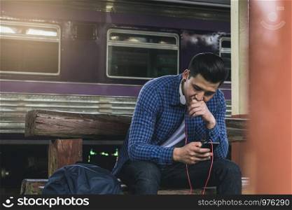 Asian man using mobile phone select song for listen music.