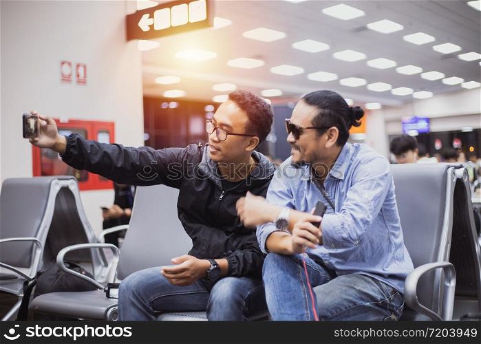 Asian man with backpack traveler using the smart mobile phone for Video call and taking photo at an airport,Blurry and soft focus
