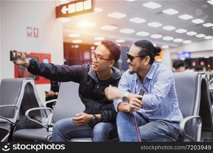 Asian man with backpack traveler using the smart mobile phone for Video call and taking photo at an airport,Blurry and soft focus