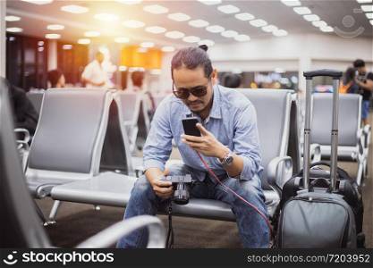 Asian man with backpack traveler using the smart mobile phone for Video call and taking at an airport,Blurry and soft focus