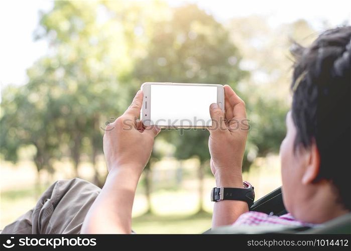 Asian men are using smartphone in the park.