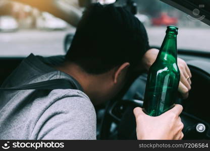 Asian men drink a lot of alcohol until and unconscious his can&rsquo;t drive home and decide to sleep at the steering wheel.