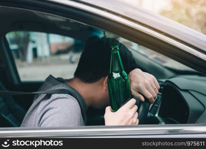 Asian men drink a lot of alcohol until and unconscious his can't drive home and decide to sleep at the steering wheel.