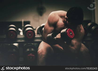 Asian men workout with dumbbell curl Concentration muscle upper arm for bodybuilding feeling so strong and powerful,Bodybuilder Concept,Low Key