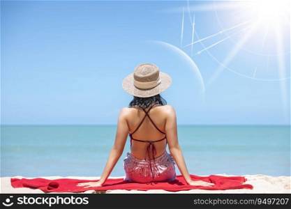 Asian model wear red swimsuit and straw hat sit on beach look view on hot day, Sun and UV rays hit the beautiful woman’s protective layer. concept about of spa, sunscreen, cosmetics, health.