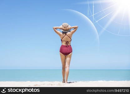 Asian model wear red swimsuit and straw hat stand on beach look view on hot day, Sun and UV rays hit the beautiful woman’s protective layer. concept about of spa, sunscreen, cosmetics, health.