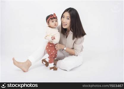 Asian mother and adorable baby girl are happy on white background
