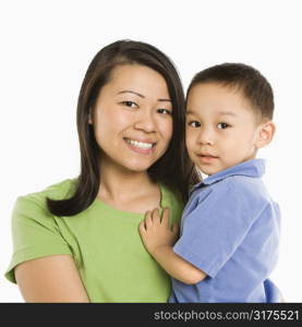 Asian mother holding son smiling in front of white background.