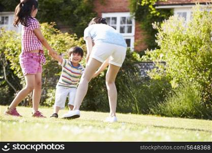 Asian Mother Playing In Summer Garden With Children