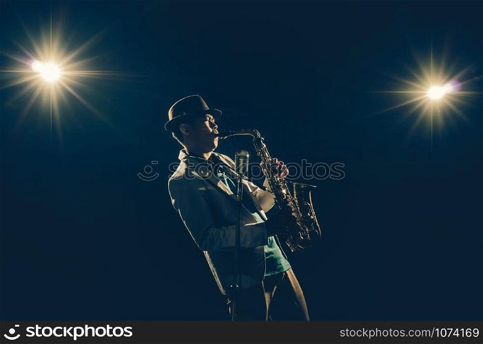 Asian Musician playing the Trumpet with spot light and lens flare on the stage, musical concept