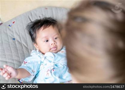 Asian newborn baby kid eye contact with mom cuteness of children with happy family on soft mattress metaphor living life healthy lifestyle cute of kid baby products health products for mother and baby