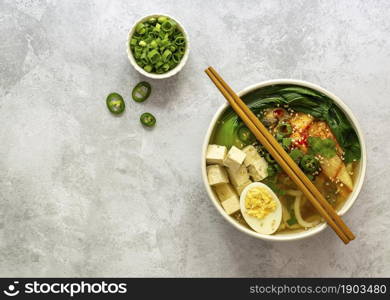 Asian noodle soup Udon with tofu, bok choy cabbage, and kimchi. Vegetarian recipe. Copy space.