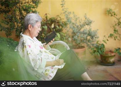 asian old asian elderly senior elder woman talking on smart mobile phone outdoor