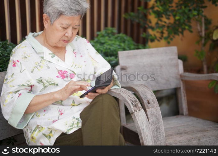 asian old elder senior woman elderly male using mobile smart phone cellphone outdoor. mature retirement lifestyle