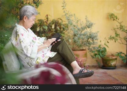 asian old elder senior woman elderly male using mobile smart phone cellphone outdoor. mature retirement lifestyle