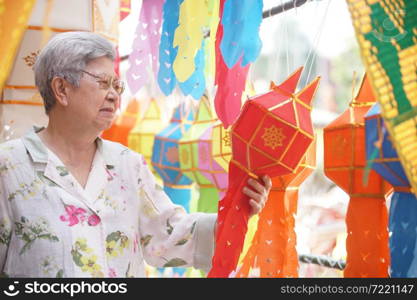 asian old elderly elder woman with hanging decorative festive paper lantern