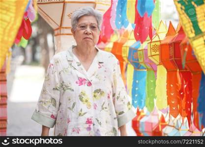 asian old elderly elder woman with hanging decorative festive paper lantern