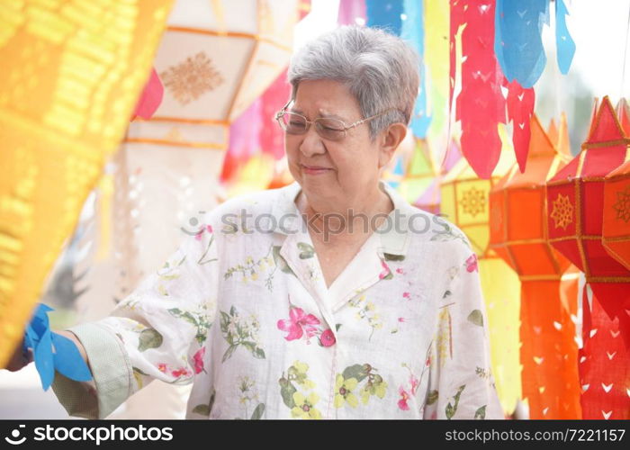 asian old elderly elder woman with hanging decorative festive paper lantern