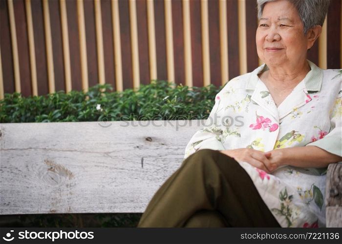 asian old elderly female elder woman resting relaxing in garden. senior leisure lifestyle