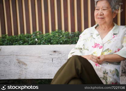 asian old elderly female elder woman resting relaxing in garden. senior leisure lifestyle