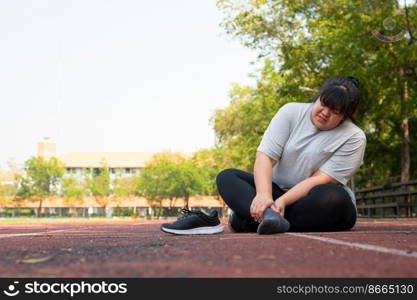 Asian overweight woman a new runner pain ankle during running, Athlete runner training accident. Sport running ankle sprained sprain cause injury. weight loss, workout, sports, health care concepts