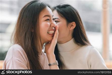 Asian pretty woman chat and gossip someone with her friend in coffee shop in winter season. Lifestyle Concept.