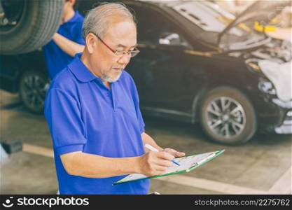 Asian professional adult garage owner working checking customer car