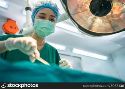 Asian Professional surgeons team performing surgery in the operating room, surgeon, Assistants, and Nurses Performing Surgery on a Patient, health care cancer and disease treatment concept