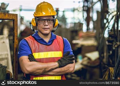 Asian Professional worker standing arm cross in heavy industry working in factory production line process with eyes and ears safety.