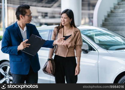 Asian receptionist welcoming the customer to visit maintainance service center for checking the car in showroom