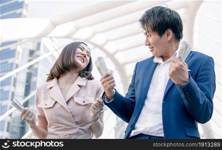 Asian rich business man and woman are very happy with a lot of money