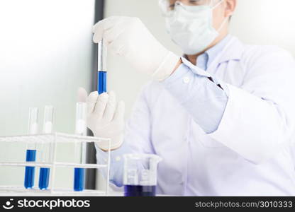 Asian scientific researcher working in laboratory holds test tube in hand a liquid solution analysis using chemical manufacturing