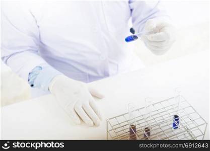 Asian scientific researcher working in laboratory holds test tube in hand a liquid solution analysis using chemical manufacturing