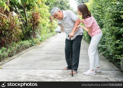 Asian senior man walking in the backyard and painful inflammation and stiffness of the joints (Arthritis) and the daughter came to help support. Concept of old elderly insurance and health care