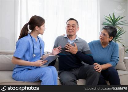 Asian senior patient talking with doctor and nurse on sofa at home