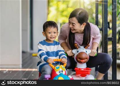 Asian single mom with son are playing with car toy together when living in modern house for Self learning or home school, Family and single mom concept, selective focus