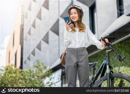 Asian smiling young woman with helmet hold mobile smart phone talk with business during go to office work at street with bicycle, Eco friendly, Lifestyle business female commuting outside in morning