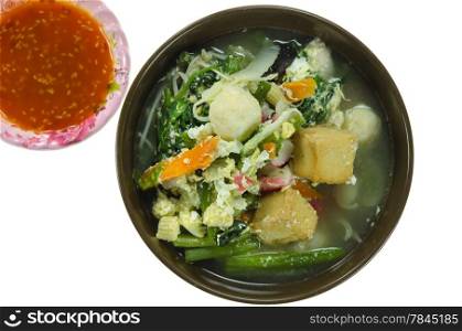asian soup with pork, meatball , egg and mix vegetable in bowl and chili sauce