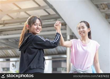 Asian Sport Fitness Women running exercise in modern city wear wellness sportswear outside. Young woman workout outdoor exercising on bright sunny outside. Healthy wellness lifestyle woman concept.