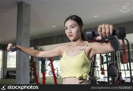 Asian sport women with dumbell in gym