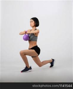 asian sporty woman in sportswear with kettlebell doing fitness workout on white background. healthy sport lifestyle