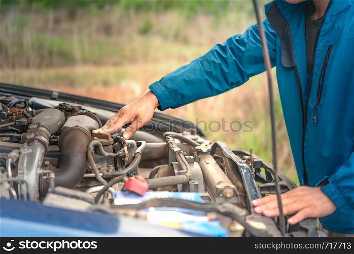 Asian stressed man having trouble with his broken car looking in frustration at failed engine. man having trouble with his broken car
