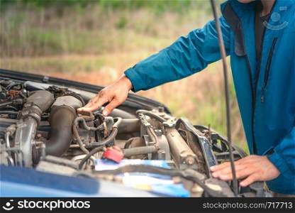 Asian stressed man having trouble with his broken car looking in frustration at failed engine. man having trouble with his broken car