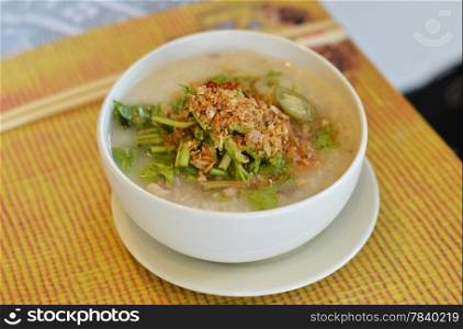 asian style rice soup with herbs in a bowl