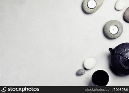 Asian tea set and spa stones on concrete background. Natural spa treatment and relaxation concept. Top view, flat lay, copyspace