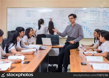 Asian teacher Giving Lesson to group of College Students in the classroom, University education concept