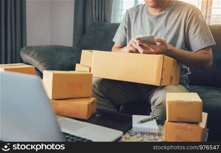 Asian teen men are looking at the phone to find the customer's address in the delivery of the product.