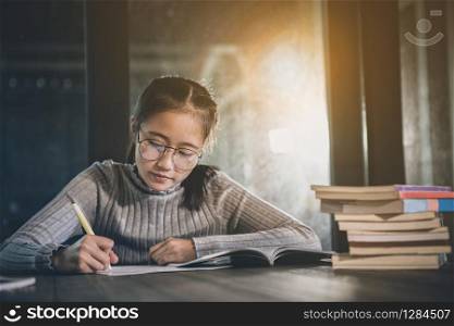 asian teenager doing school home work in library room
